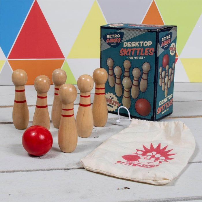 image of six light brown wooden style skittles with two horizontal red stripes on each and a classic red skittles ball with a retro style skittles box. 